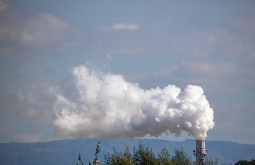 A scenic view of white smoke coming out of an industrial chimney