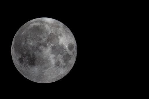 A closeup shot of the full moon on the black background