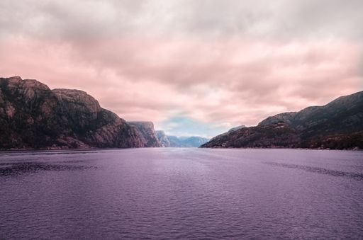A beautiful scenery of the sea surrounded by high rock formations under the storm clouds in Norway