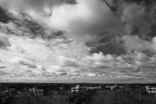A grayscale shot of cloudy sky over the countryside
