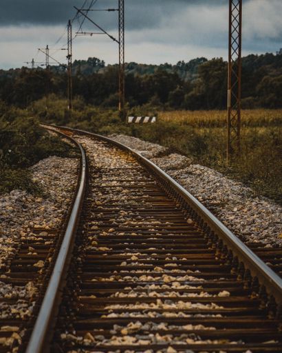A vertical shot of rusty train tracks through rural areas in Bosnia and Herzegovina