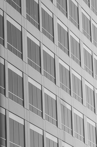 A vertical minimalistic grayscale of a modern office building exterior
