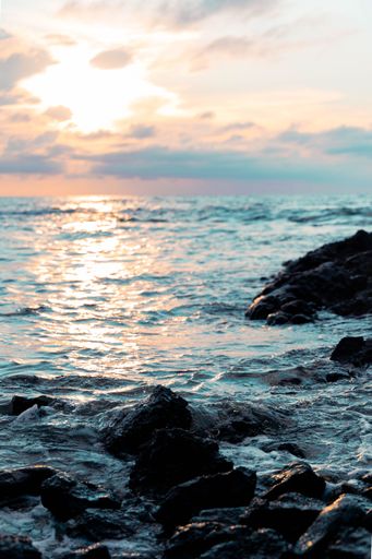 A vertical shot of the beautiful rocky seashore of Hawaii at sunset