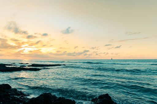 A high angle shot of the beautiful rocky seashore of Hawaii at sunset