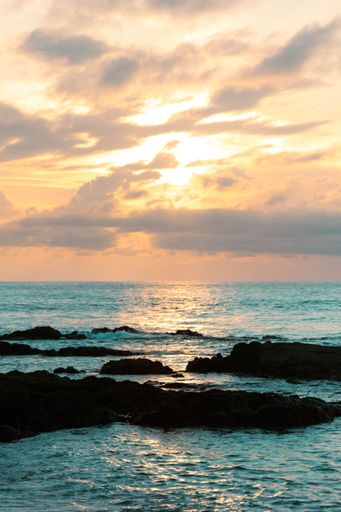 A vertical shot of the beautiful rocky seashore of Hawaii at sunset