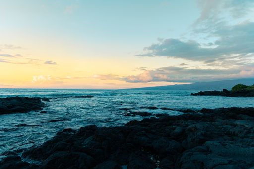 A high angle shot of the beautiful rocky seashore of Hawaii at sunset