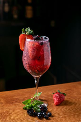 A vertical shot of a glass of gin tonic with berries
