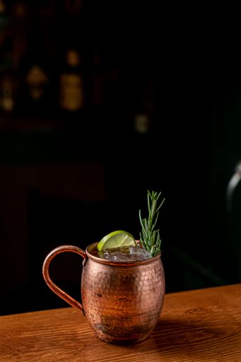 A copper mug of Moscow mule cocktail served on a bar counter