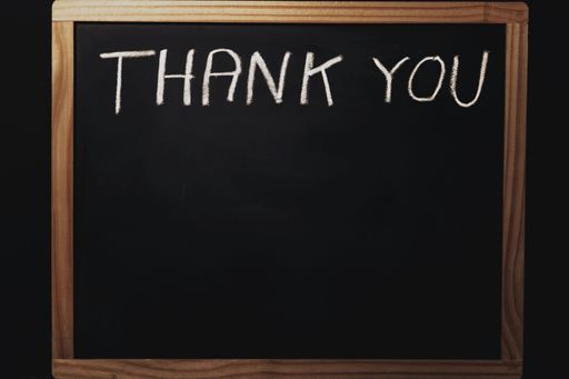 word thank you written on a black chalkboard with chalk