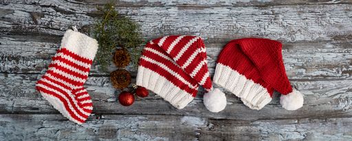 christmas hat and decorative sock knitted with wool on rustic background