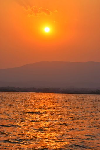 A vertical shot of a bright orange sunset over the sea