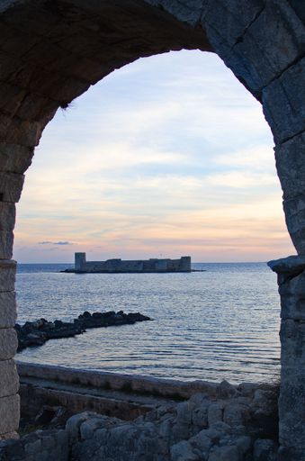 A vertical shot of Korykos Castle seen trhough arch during the sunset