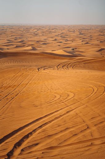 A vertical shot of sand dunes in a desert in Dubai, United Arab Emirates