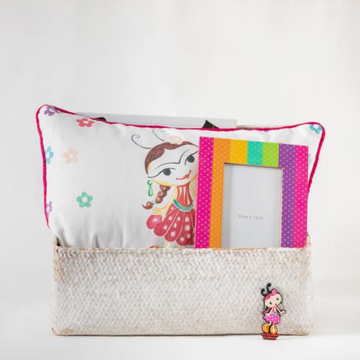 A closeup shot of a pillow with cute drawings on it and picture frames in a box