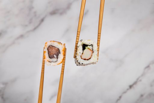 A close-up shot of a set of delicious sushi rolls with chopsticks