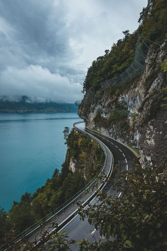 A curve road on the edge of the cliff overlooking the ocean on a dark cloudy day