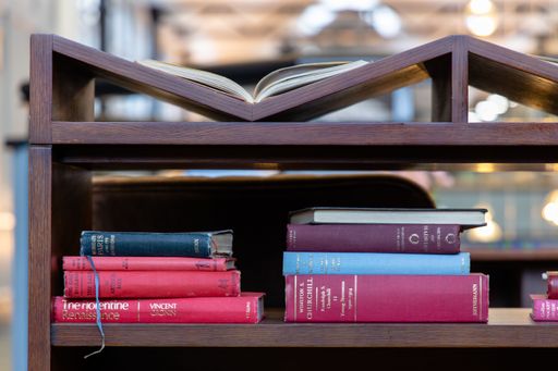 A closeup of old books on a shelf in the blurry background