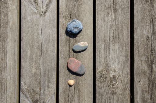 A closeup top view of small beach cobbles isolated on a wooden board