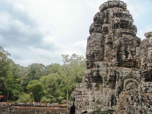 An image of a stone statue in front of trees in Angkor Wat, Cambodia