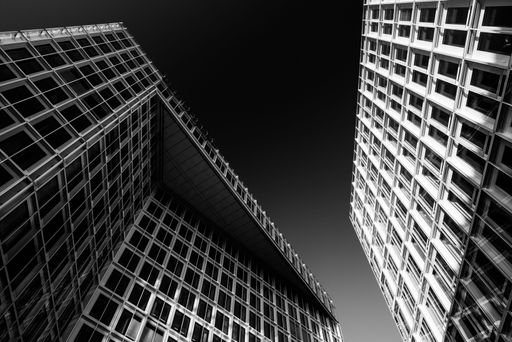 A low angle greyscale shot of modern buildings with beautiful architecture