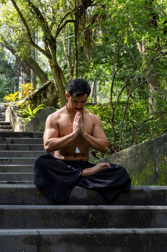A young Hispanic man doing meditation on a stairway in a forest, Mexico, Guadalajara