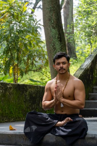 A young Hispanic man doing meditation on a stairway in a forest, Mexico, Guadalajara