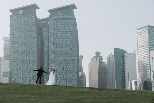 A happy newly married couple in front of skyscrapers in Doha, Qatar