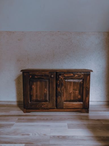 A vertical shot of a wooden nightstand in the room
