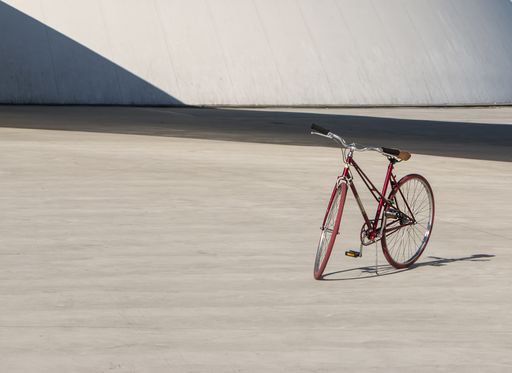 A red bicycle parked during the daytime