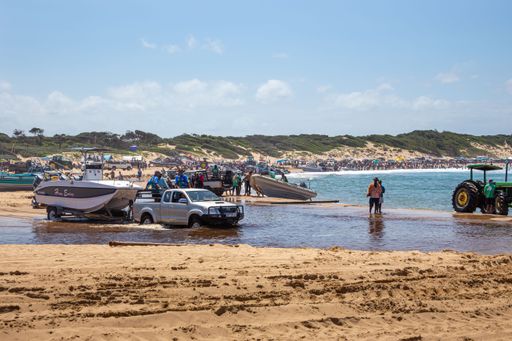 A busy day during summer on Sodwana Bay in South Africa, where people launch their boats off the beach and into the surf.