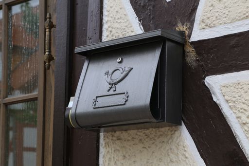 A closeup of a black post box