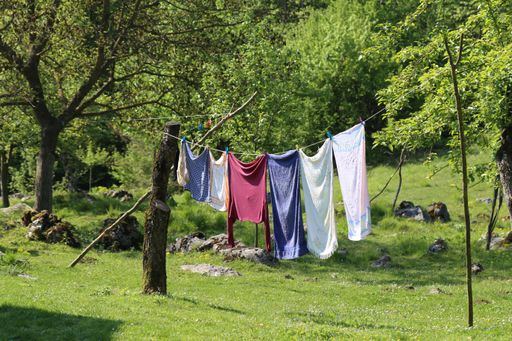 The laundry hanging on a rope and drying in the backyard of a house