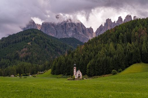 Beautiful Church of St John of Nepomuk (Chiesetta di San Giovanni) in Ranui with a dramatic sky, Val di Funes, Dolomites, Italy