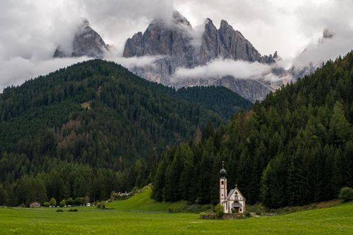 Beautiful Church of St John of Nepomuk (Chiesetta di San Giovanni) in Ranui with a dramatic sky, Val di Funes, Dolomites, Italy