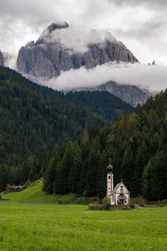 Beautiful Church of St John of Nepomuk (Chiesetta di San Giovanni) in Ranui with a dramatic sky, Val di Funes, Dolomites, Italy