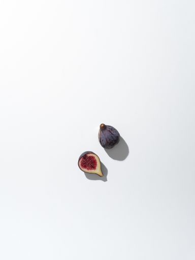 A vertical closeup shot of a while fig and a half isolated on a white background