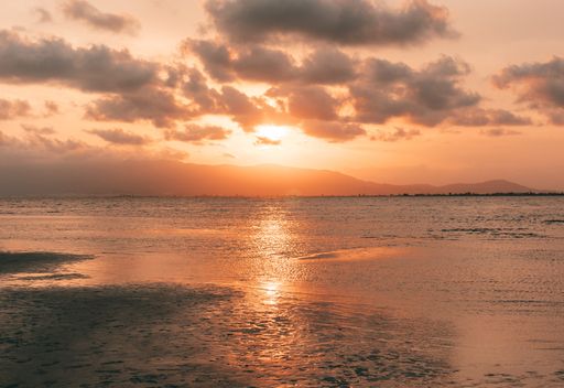 A mesmerizing view of a light orange shaded sunset on the sea
