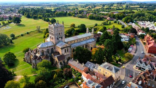 A beautiful aerial view of the Tewkesbury Abbey in England surrounded by lush green trees and buildings