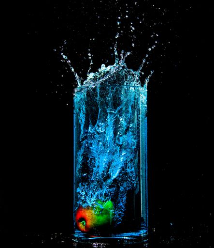 an Apple which drops into a glass full of water