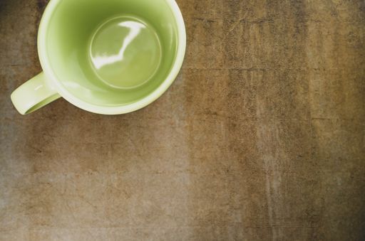 A high angle shot of a green mug on a table