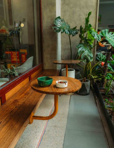 A vertical shot of wooden tables attached to a seat in a cafe in Ho Chi Minh City, Vietnam