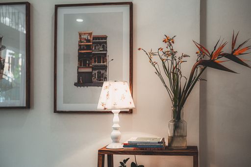 A wooden shelf with a lamp, a vase with flowers and books in a cafe in Ho Chi Minh City, Vietnam