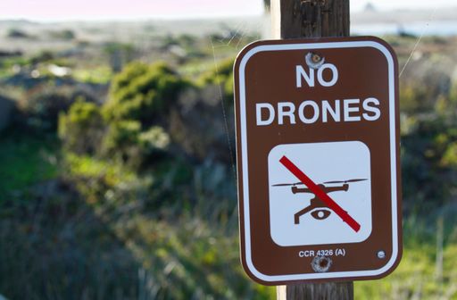 A closeup of 'no drone' sign in blurred background