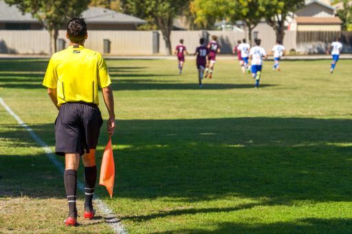 The soccer referee in a yellow shirt in the field