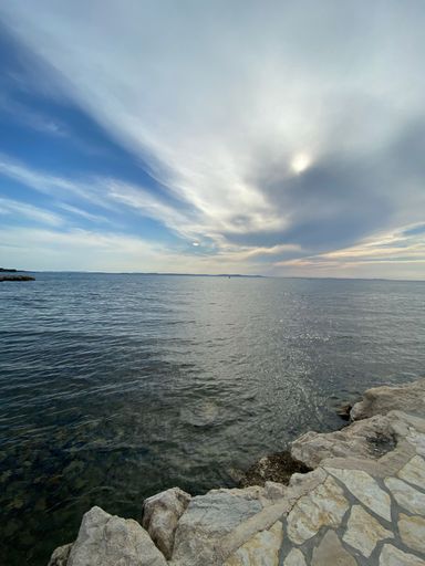 A vertical shot of a beautiful seascape under a cloudy sky
