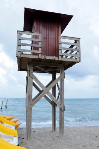 A vertical shot of a wooden rescue tower on a beach