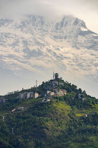 A vertical shot of the green hill and Annapurna mountain range in the background. Pokhara, Nepal.