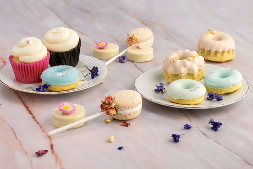 A wooden table with donuts, macaroons and dried flowers for a birthday party