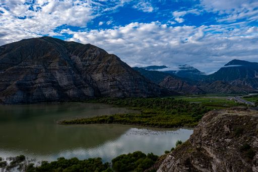 A mesmerizing view of the lake with rocky mountains against the blue sky