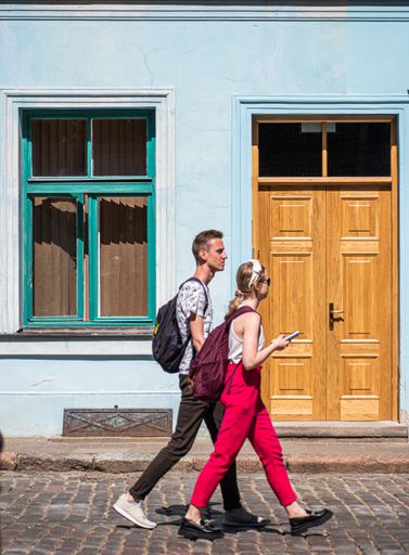 A vertical shot of a couple walking down the street. Riga, Latvia.